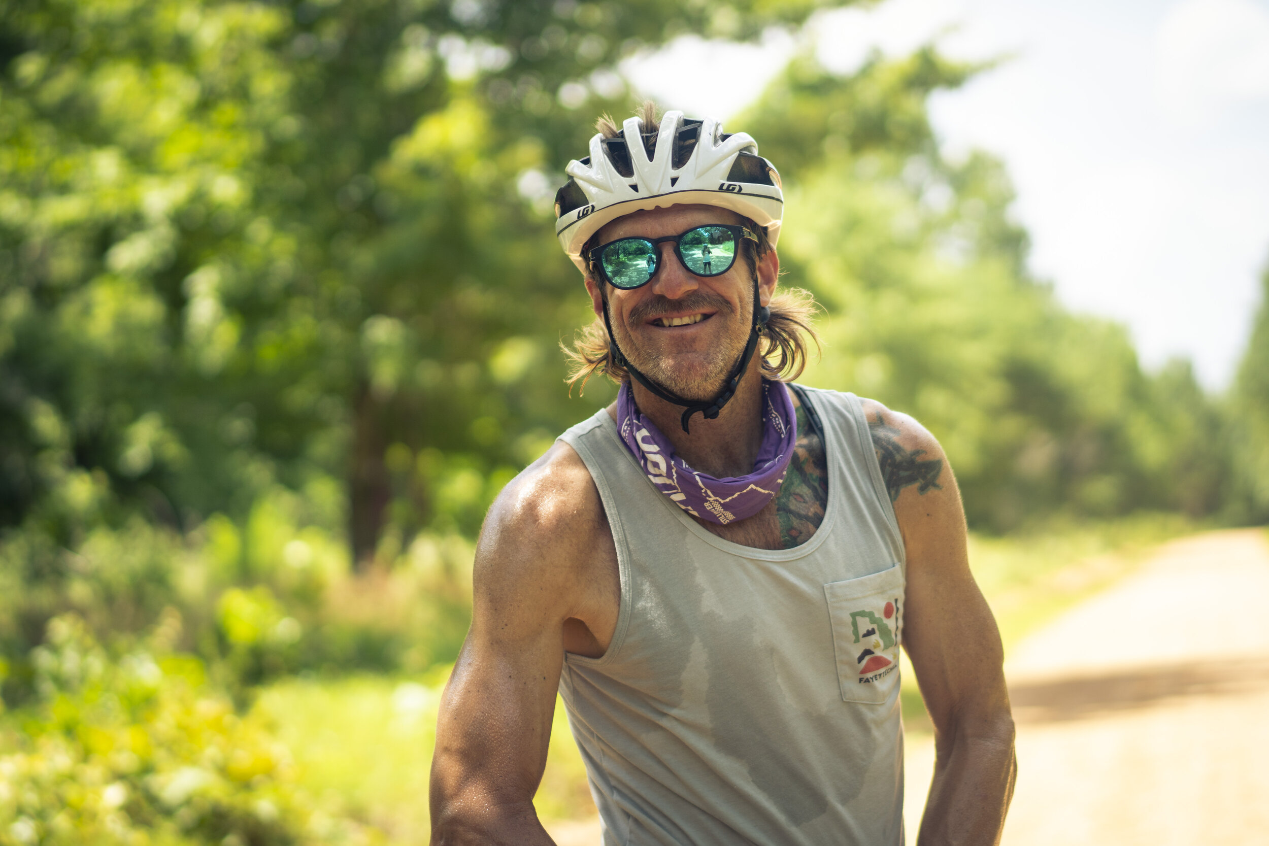 Male rider smiling for a portrait with his helmet.