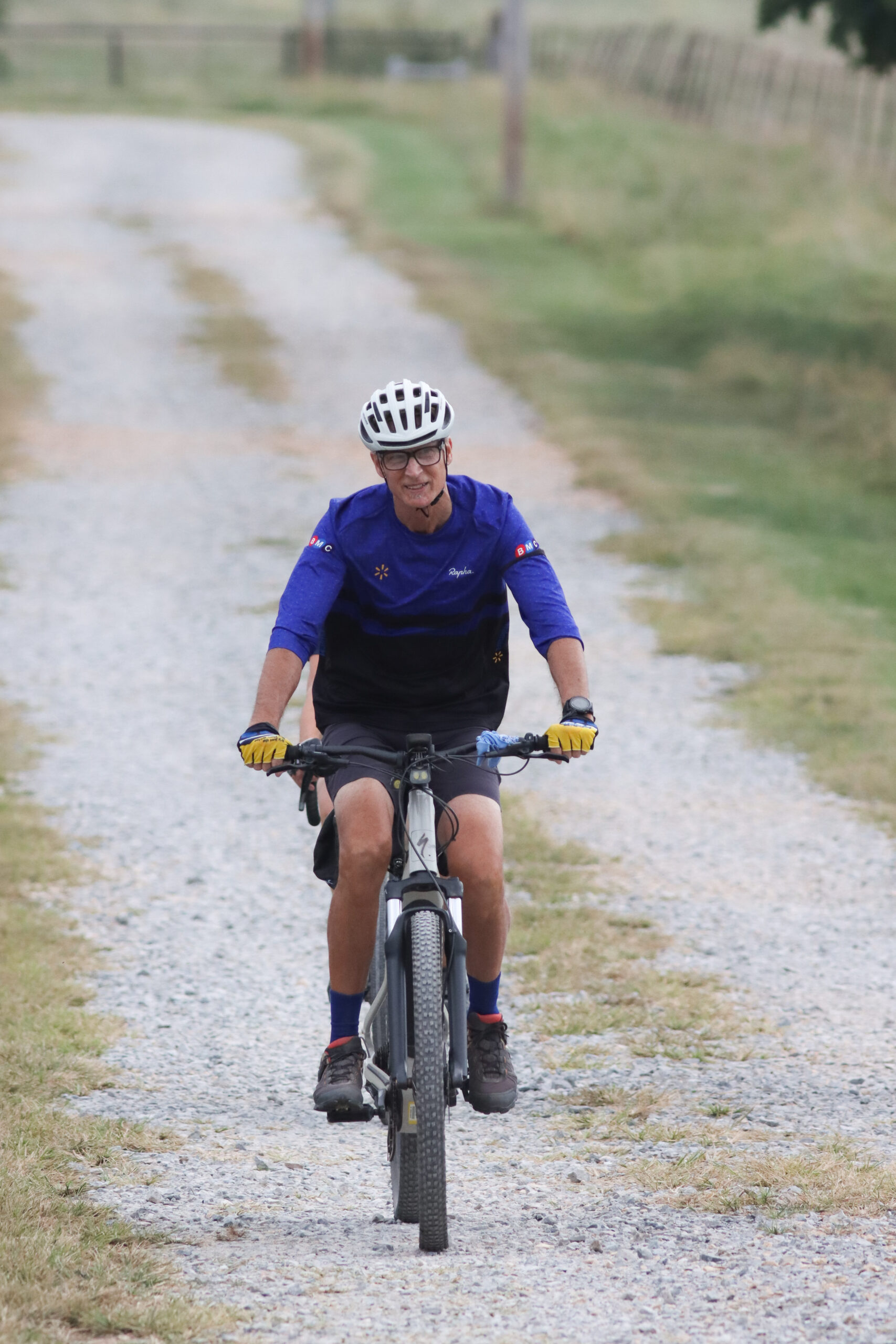 A biker rides his mountain bike on a gravel road