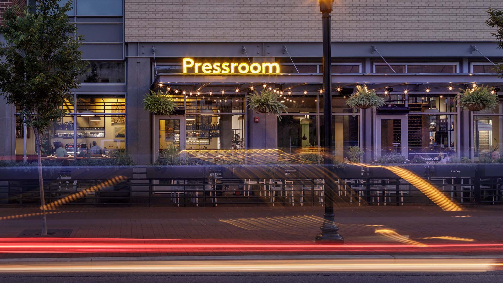 Pressroom patio at dusk with a long exposure light trail.
