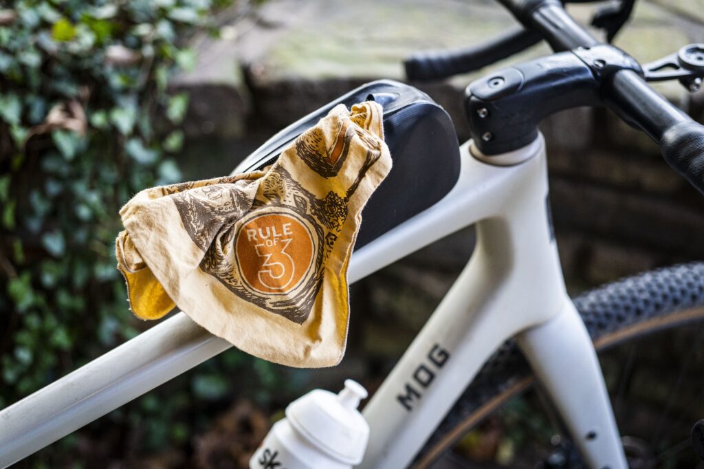 A bandana hangs out of a bike top tube bag.